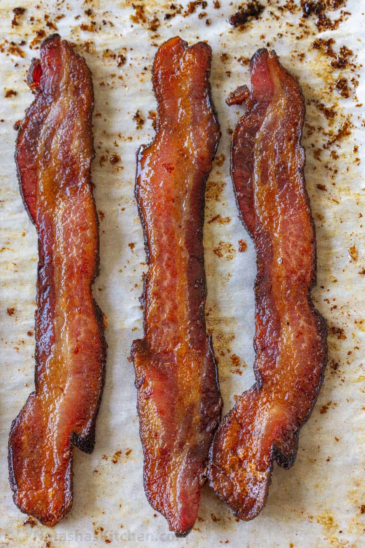 How to bake bacon in the oven that is perfectly crispy. Oven-baked bacon is the best for making a bigger batch and it's the easiest method. Strips of oven-baked bacon cooked to perfection