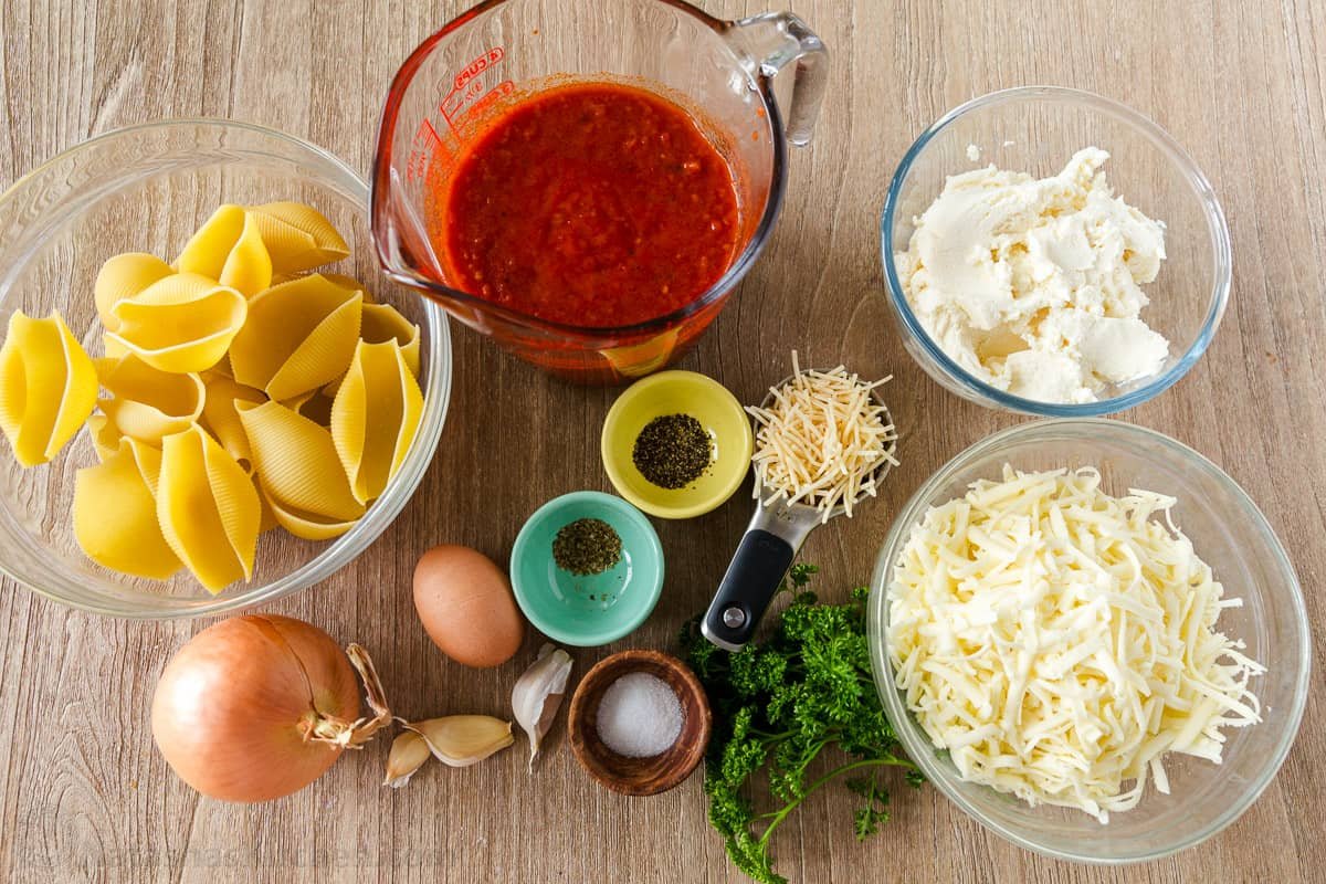 Stuffed Shells filled with ricotta, parmesan, and melty mozzarella cheese. Stuffed Pasta Shells always disappear fast and reheat well. Recipe ingredients with jumbo shells, cheese, marinara, onion and garlic
