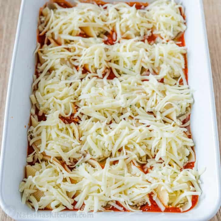 Shells topped with cheese and ready to be baked