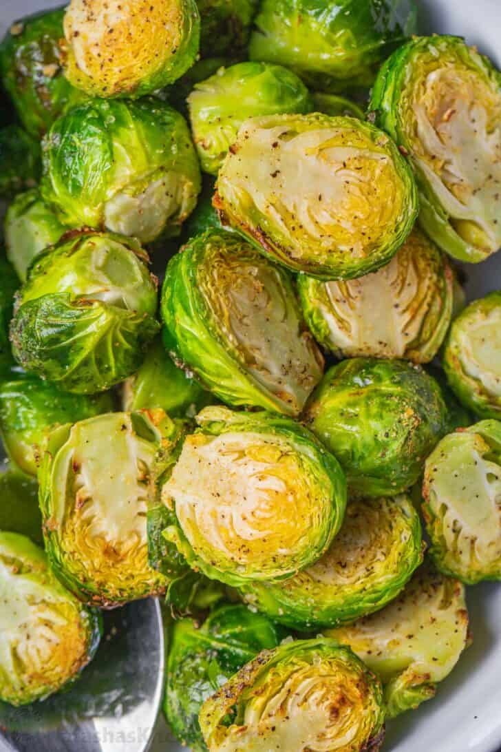 Easiest recipe for homemade brussels srouts in an air fryer. Air Fried Brussels sprouts served in a bowl.