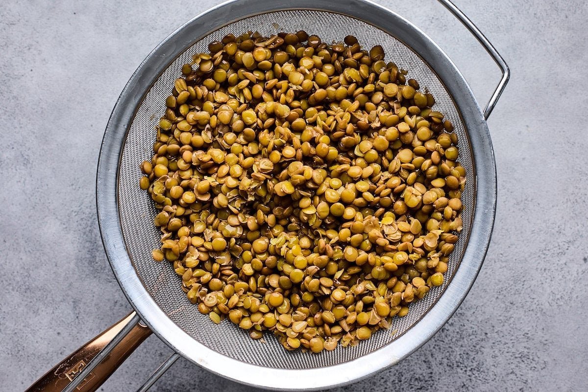 cooked lentils in strainer.