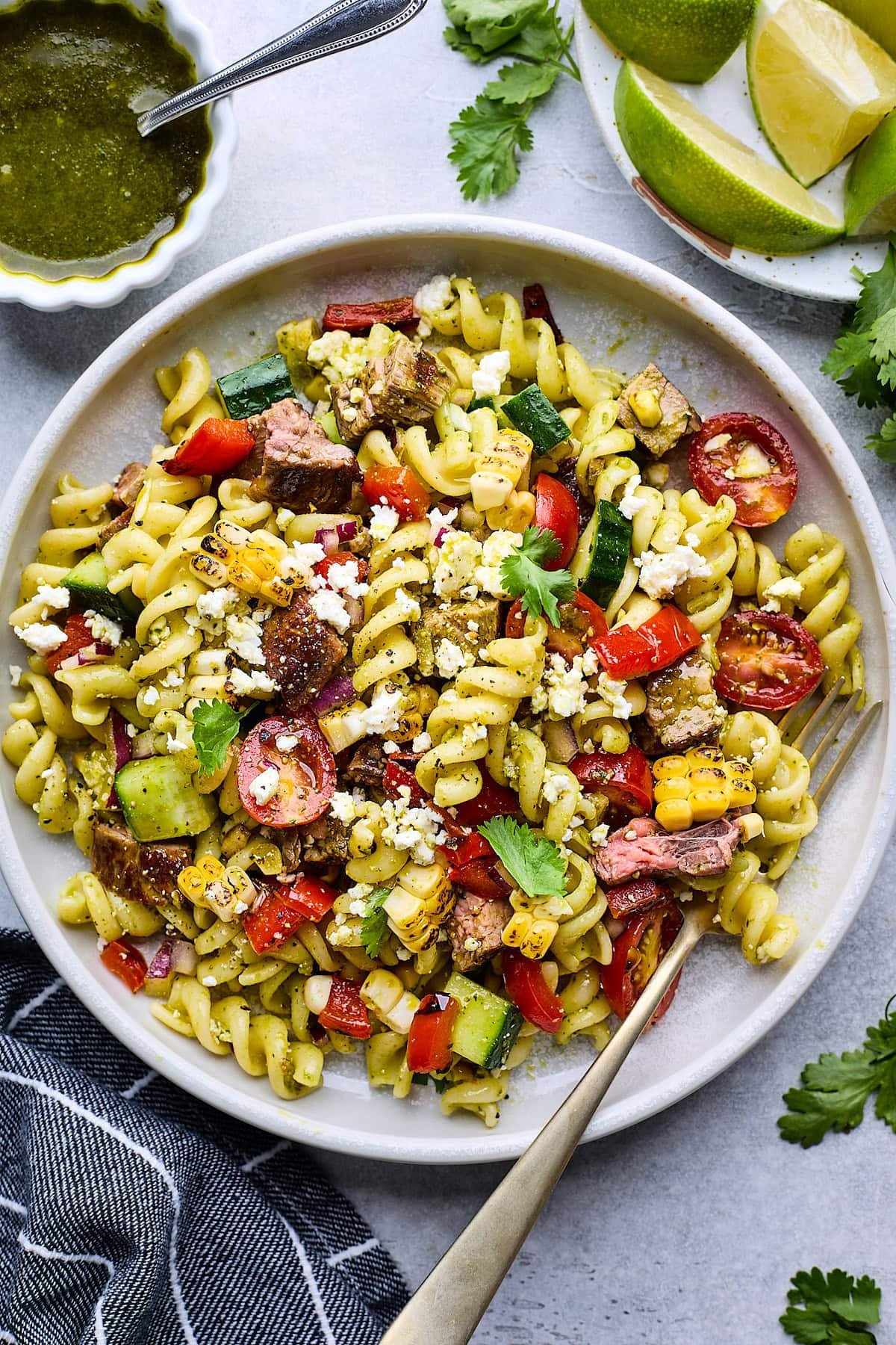steak pasta salad on plate with fork.