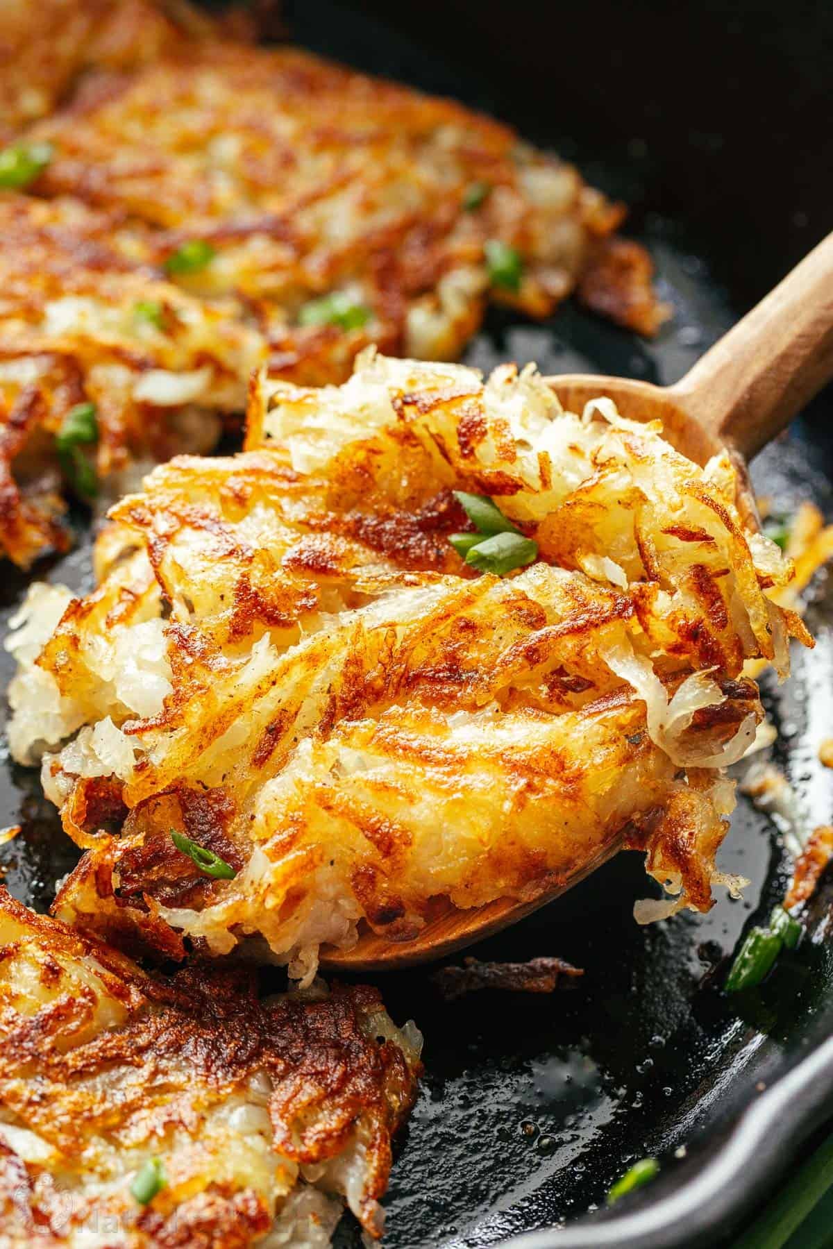 Here’s the secret to making the best Crispy Hash Browns - the perfect breakfast side dish. A classic homemade Hash Brown Recipe. crispy golden hash browns on serving spoon