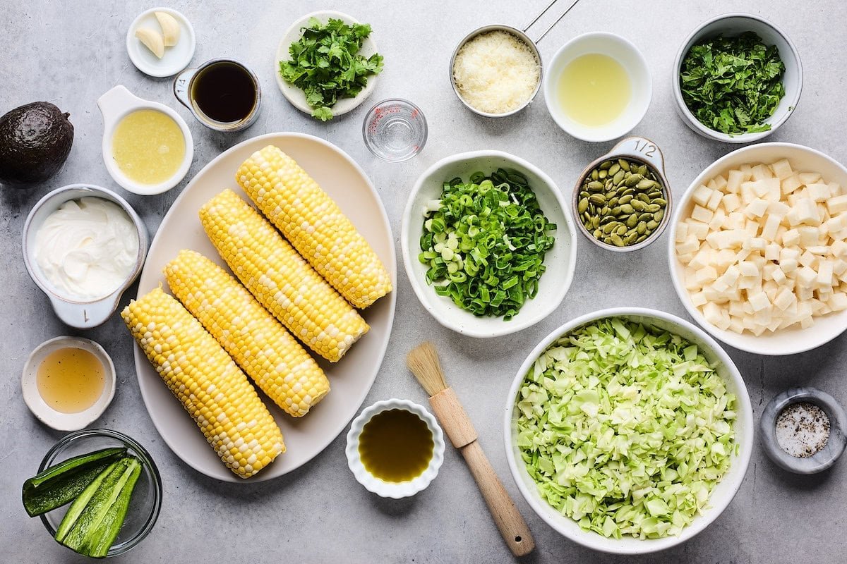 ingredients in bowls to make charred corn cabbage salad with creamy avocado dressing.