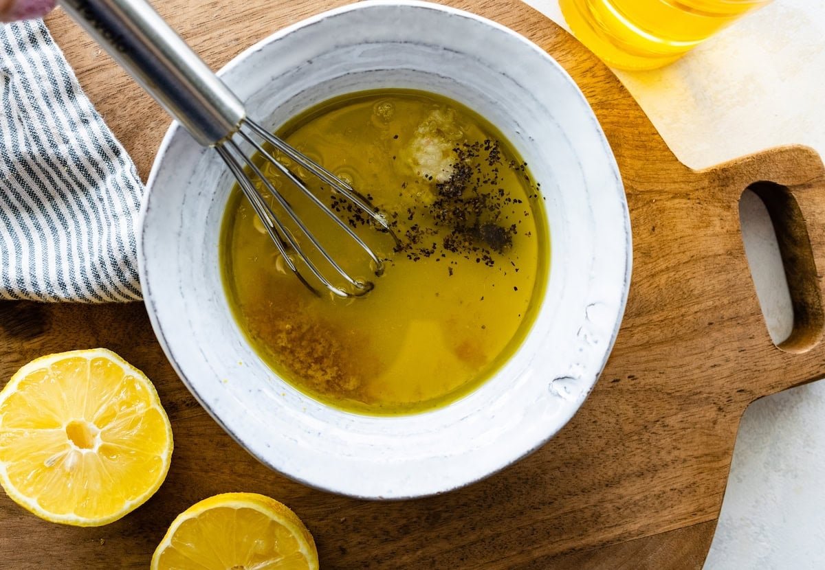 lemon dressing in bowl with whisk.