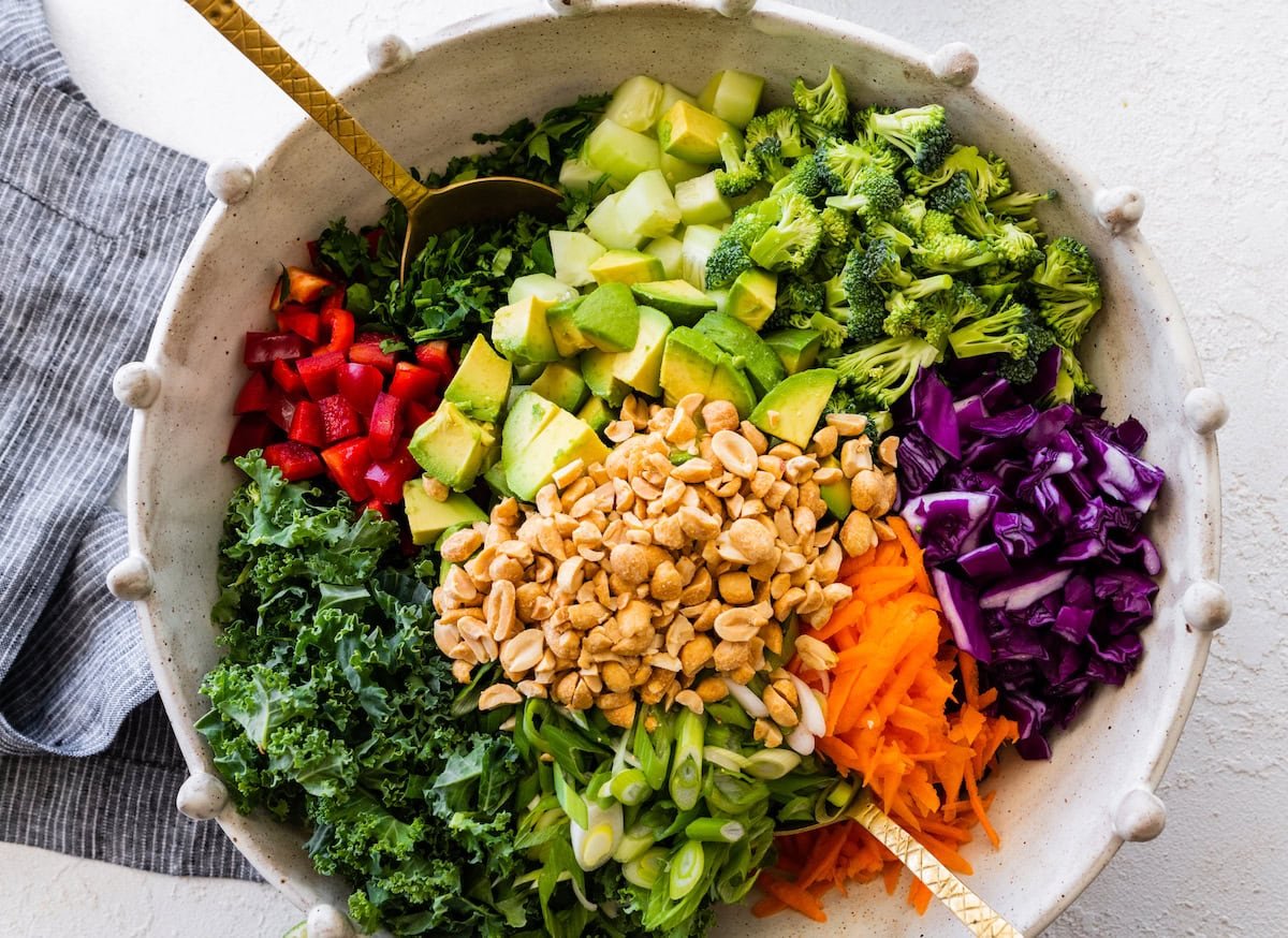 asian inspired kale broccoli salad in bowl ready to be tossed.