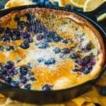 dutch baby pancake in skillet with powdered sugar