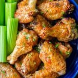 Air Fryer chicken wings garnished with parsley in blue bowl
