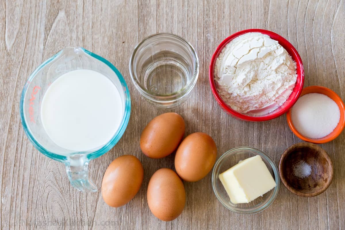 Ingredients for making French Crepes with milk, water, eggs, flour, butter, sugar and salt