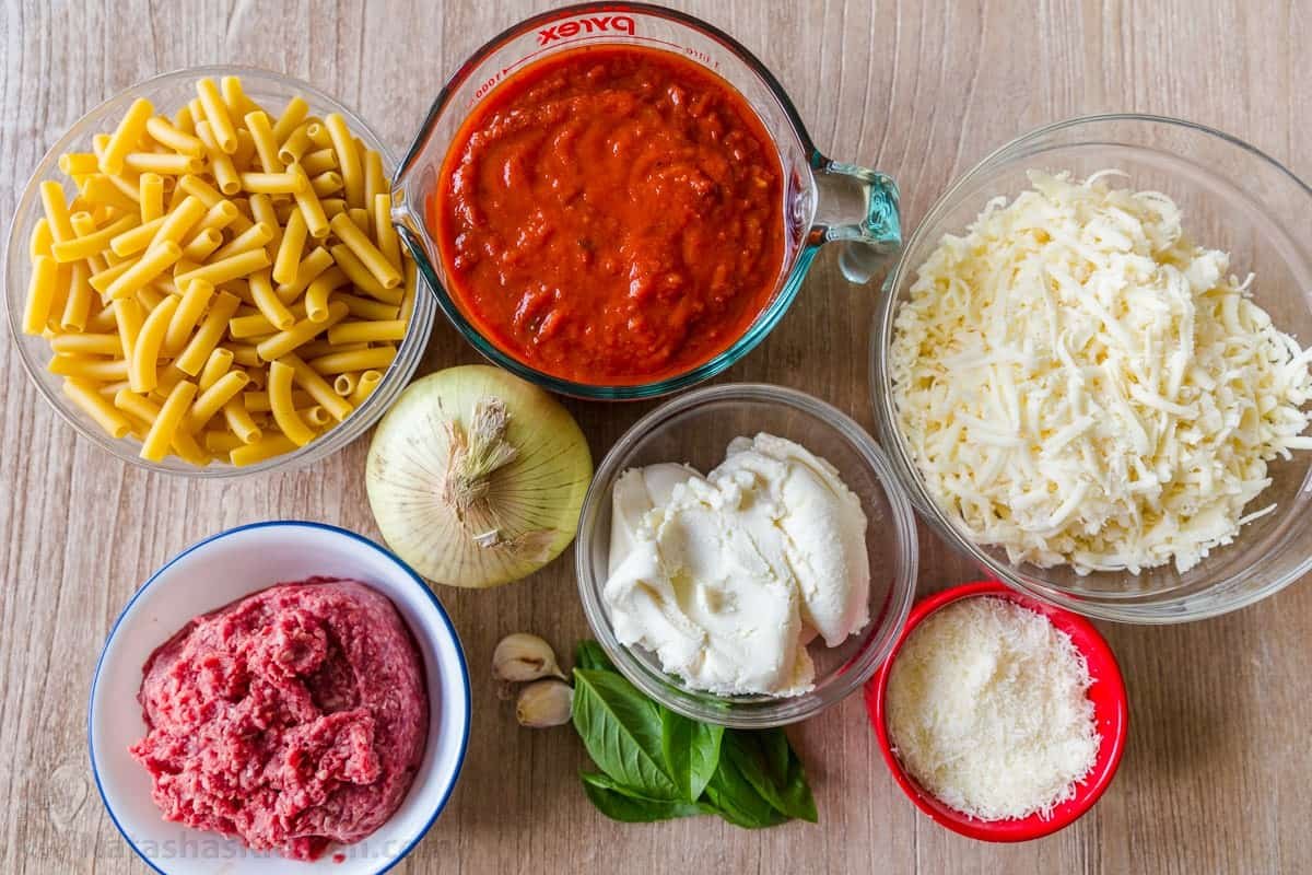 Ingredients for ziti casserole: Ziti pasta, ground beef, basil, ricotta cheese, mozzarella and Parmesan cheese, onion, garlic