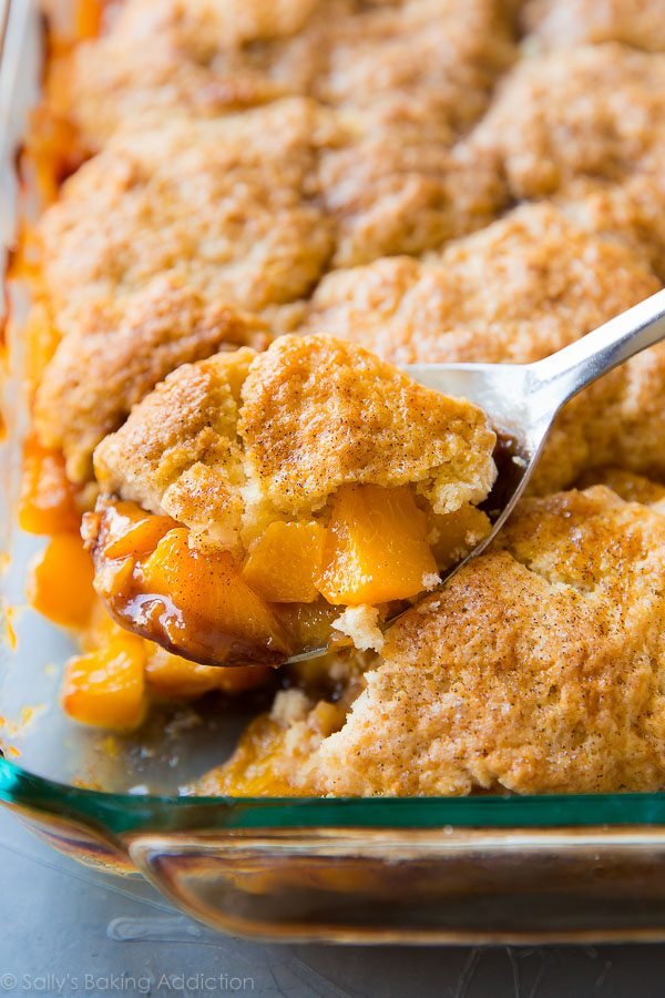 serving spoon full of peach cobbler