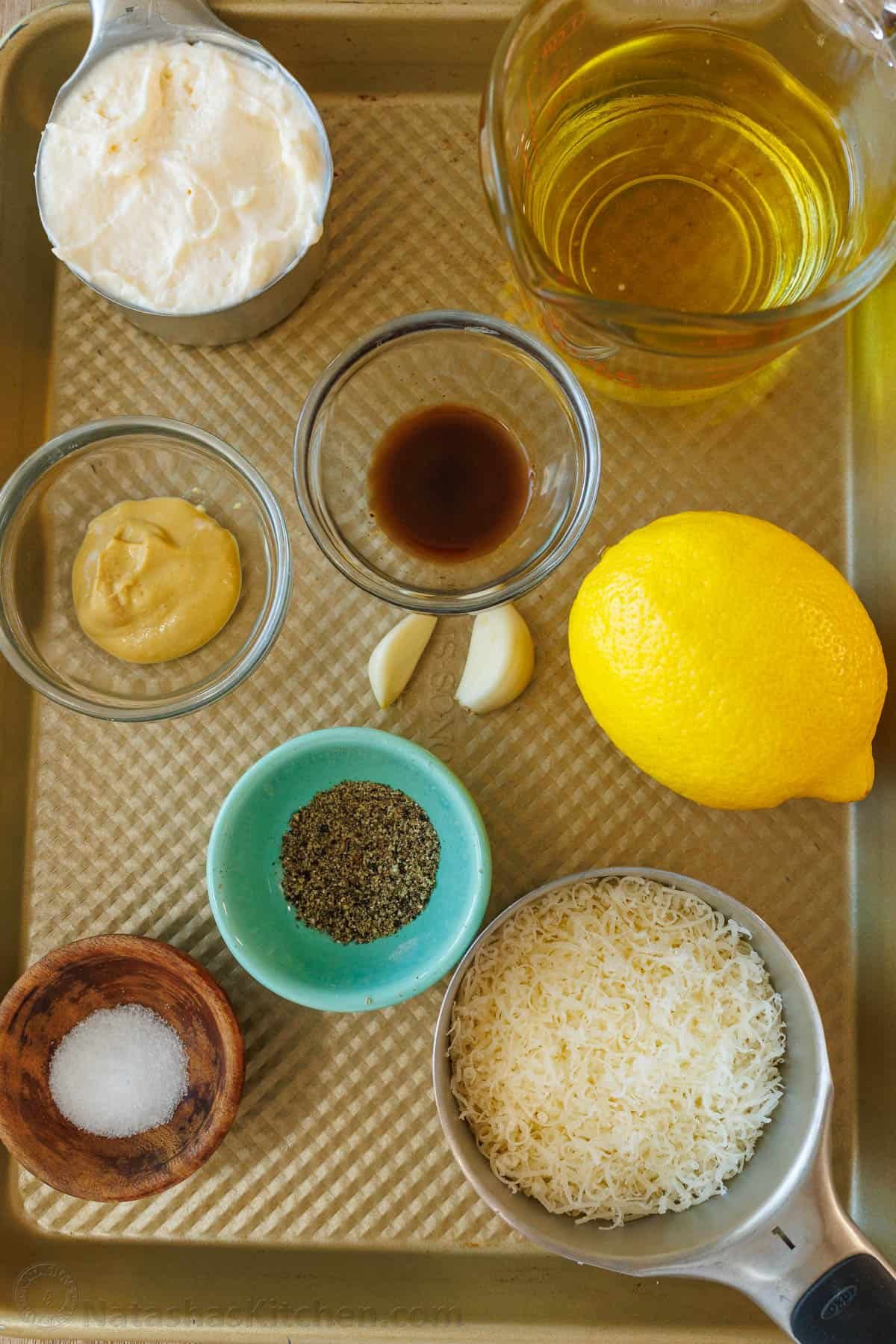Ingredients for easy caesar dressing, mayonnaise, oil, dijon mustard, garlic, Worcestershire sauce, lemon juice, salt, pepper, parmesan cheese