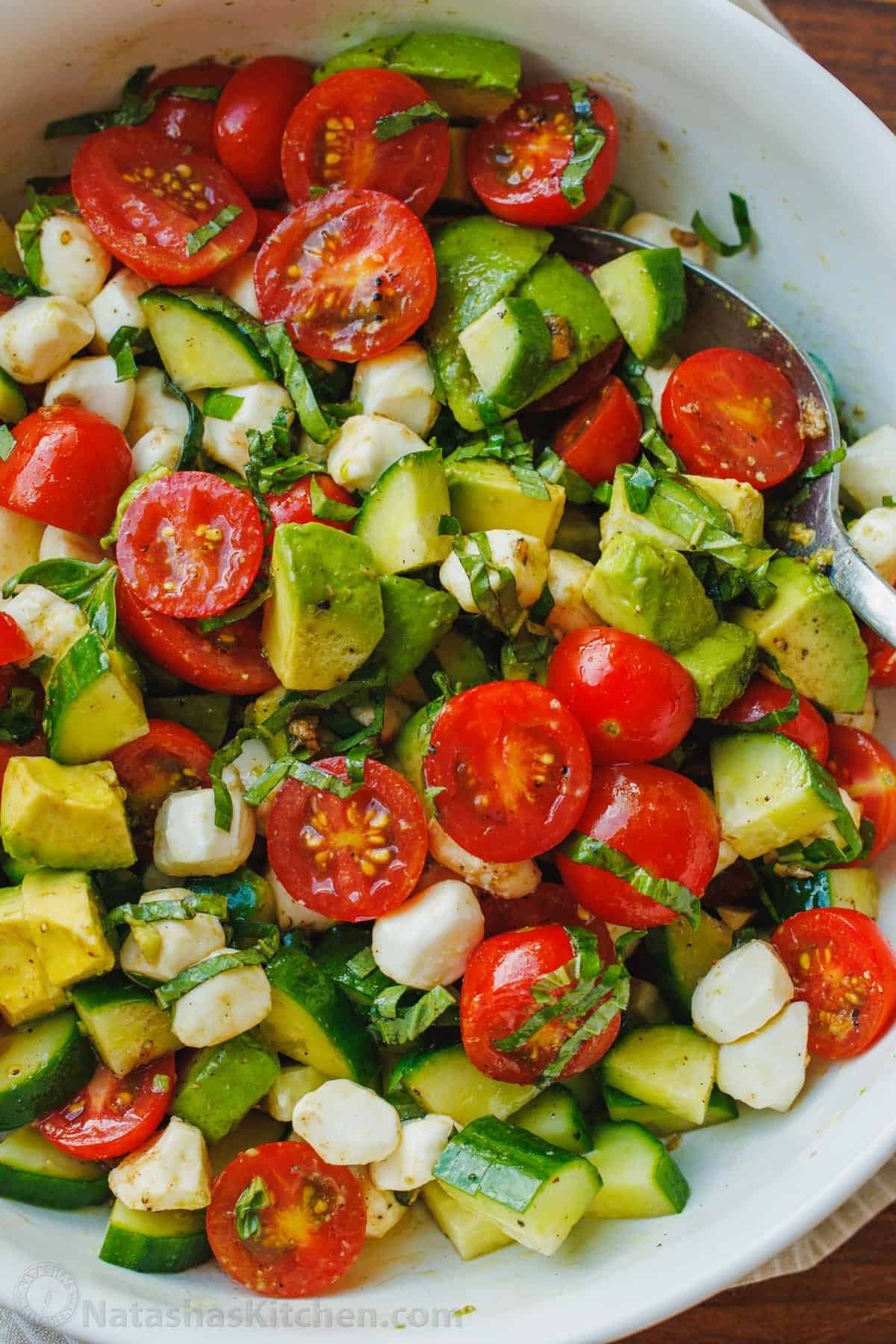 Tomato mozzarella salad with avocado and cucumber and balsamic dressing