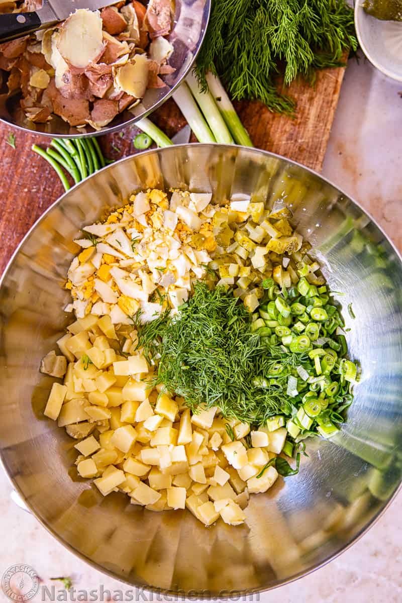 Diced potato salad ingredients in a metal bowl without potato salad dressing