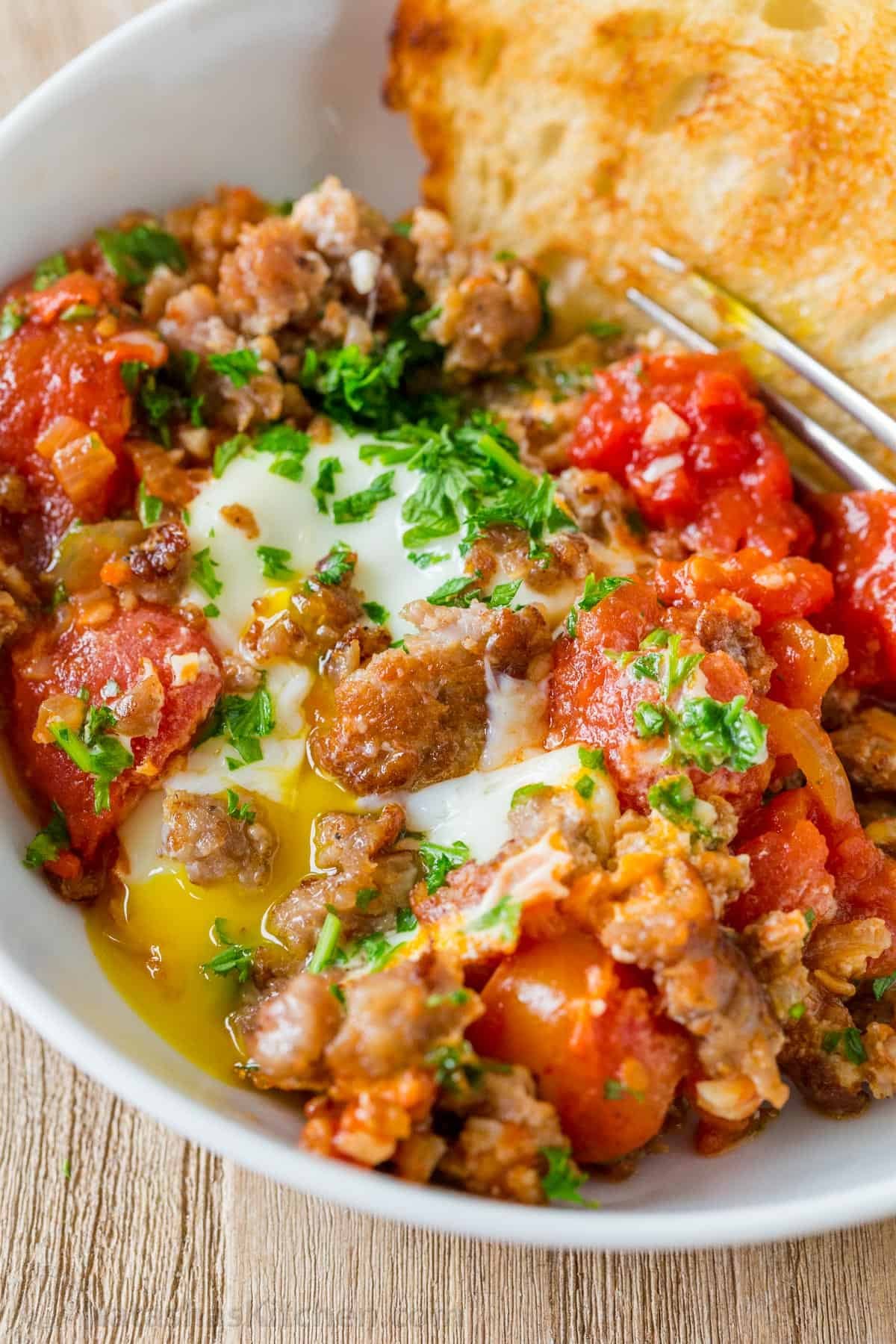 Shakshuka served in a bowl with toasted bread