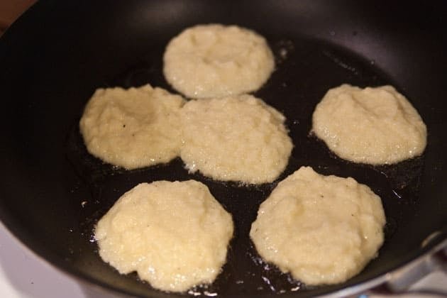 Potato pancakes being fried in a skillet 