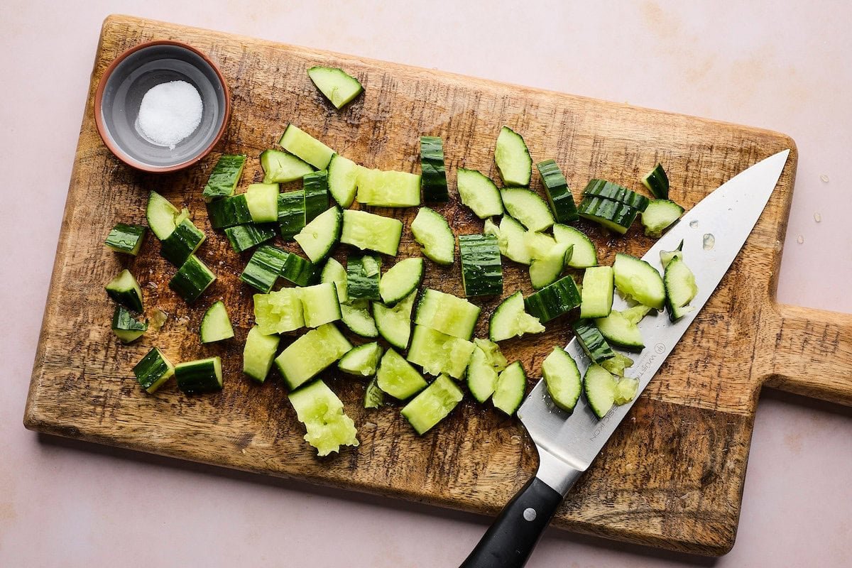 smashed cucumbers on wood cutting board. 