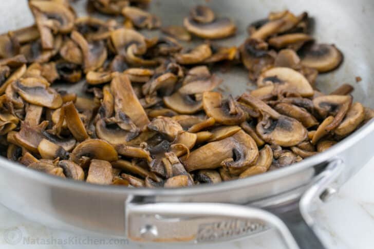 These Breakfast Burritos will make a breakfast person out of you. Crisp on the outside and filled with egg, ham, and cheese. Easy freezer breakfast burritos! Sautéed mushrooms in a pan