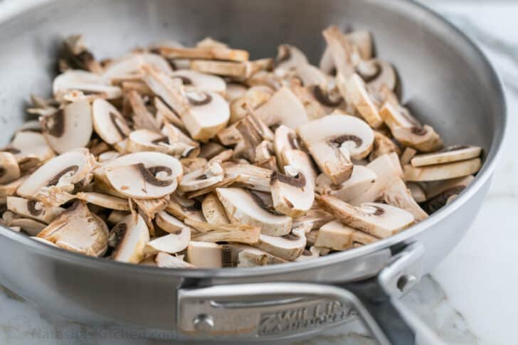 These Breakfast Burritos will make a breakfast person out of you. Crisp on the outside and filled with egg, ham, and cheese. Easy freezer breakfast burritos! Sliced mushrooms in a pan to sautée