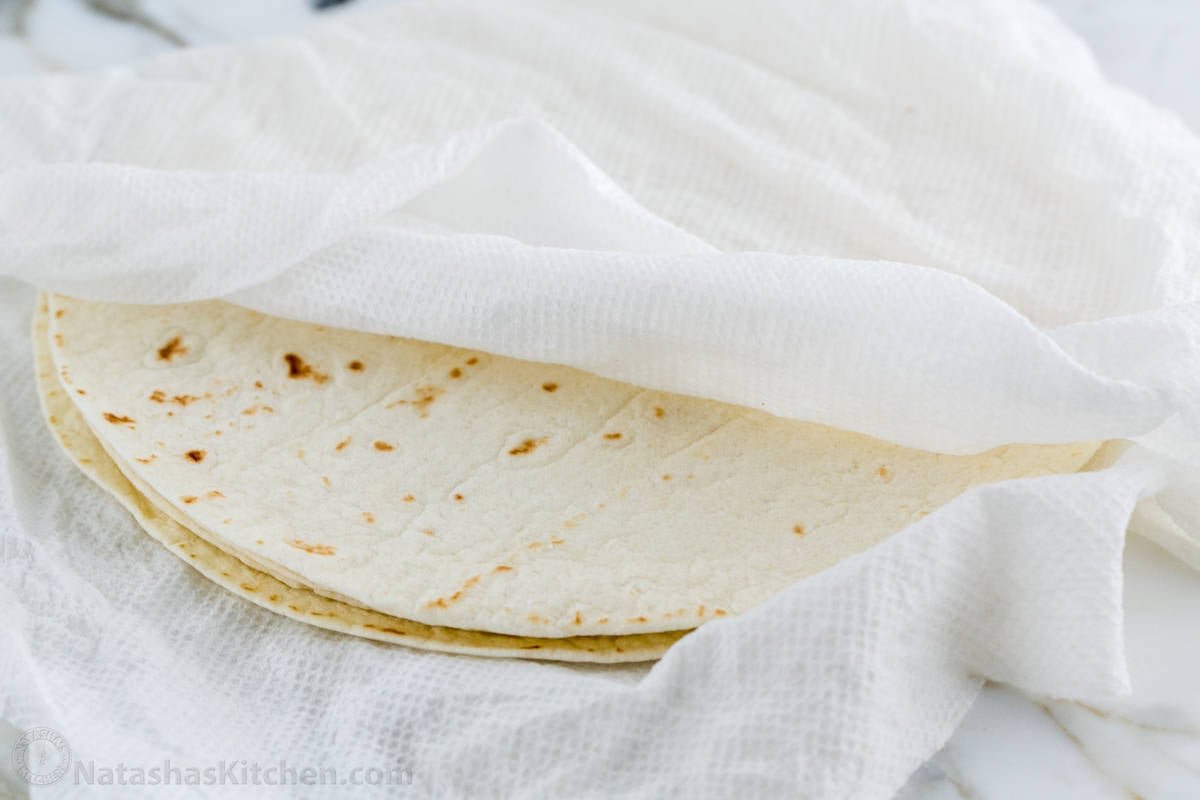 These Breakfast Burritos will make a breakfast person out of you. Crisp on the outside and filled with egg, ham, and cheese. Easy freezer breakfast burritos! Tortillas wrapped in a barely damp paper towel