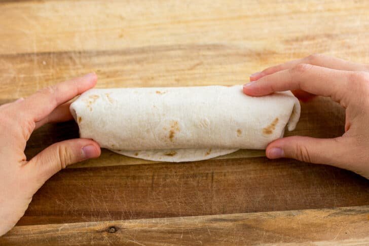 These Breakfast Burritos will make a breakfast person out of you. Crisp on the outside and filled with egg, ham, and cheese. Easy freezer breakfast burritos! The final roll to seal your breakfast burrito