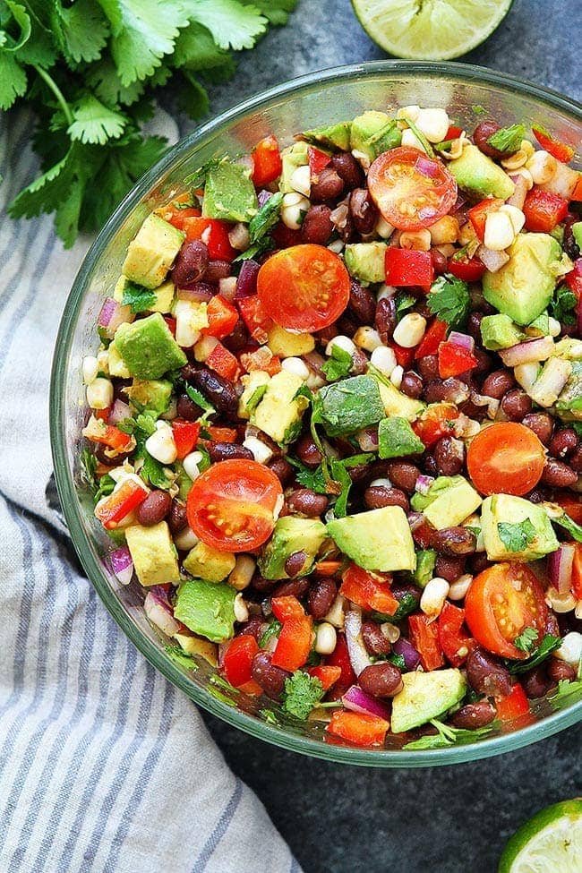 Black Bean Salad with avocado and tomatoes in glass bowl. 