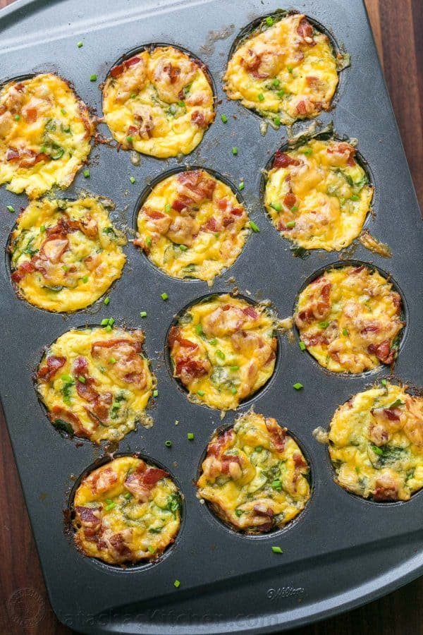 Breakfast egg muffins with potato, spinach, eggs, cheese and crisp bacon in muffin tin