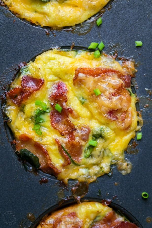 Up close egg muffin garnished with chives and bacon