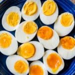 Boiled eggs peeled and halved on blue platter