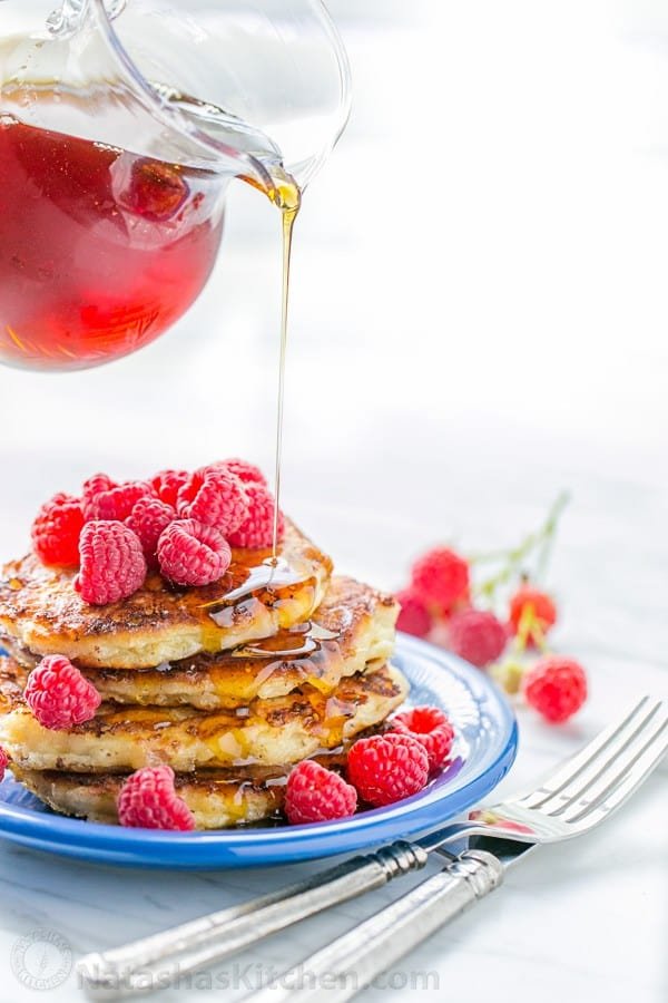 Cottage cheese pancakes served with raspberries and maple syrup