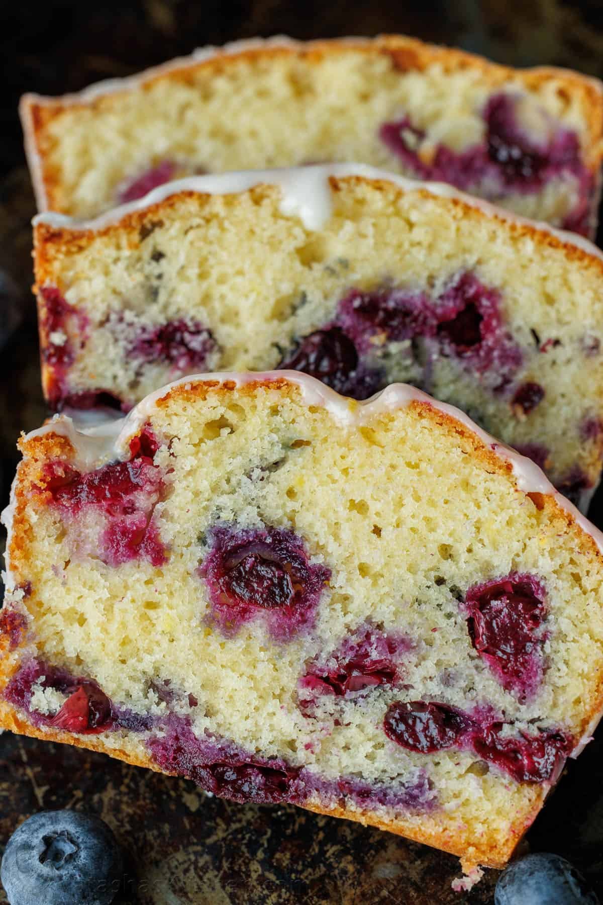 This Lemon Blueberry Bread has a moist and tender crumb and is loaded with blueberries. Don't skip the lemon glaze - you'll love every bite! Blueberry Lemon Bread sliced to showcase juicy blueberries baked in the batter