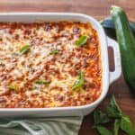 Zucchini Lasagna served in a white dish with zucchini and basil leaves