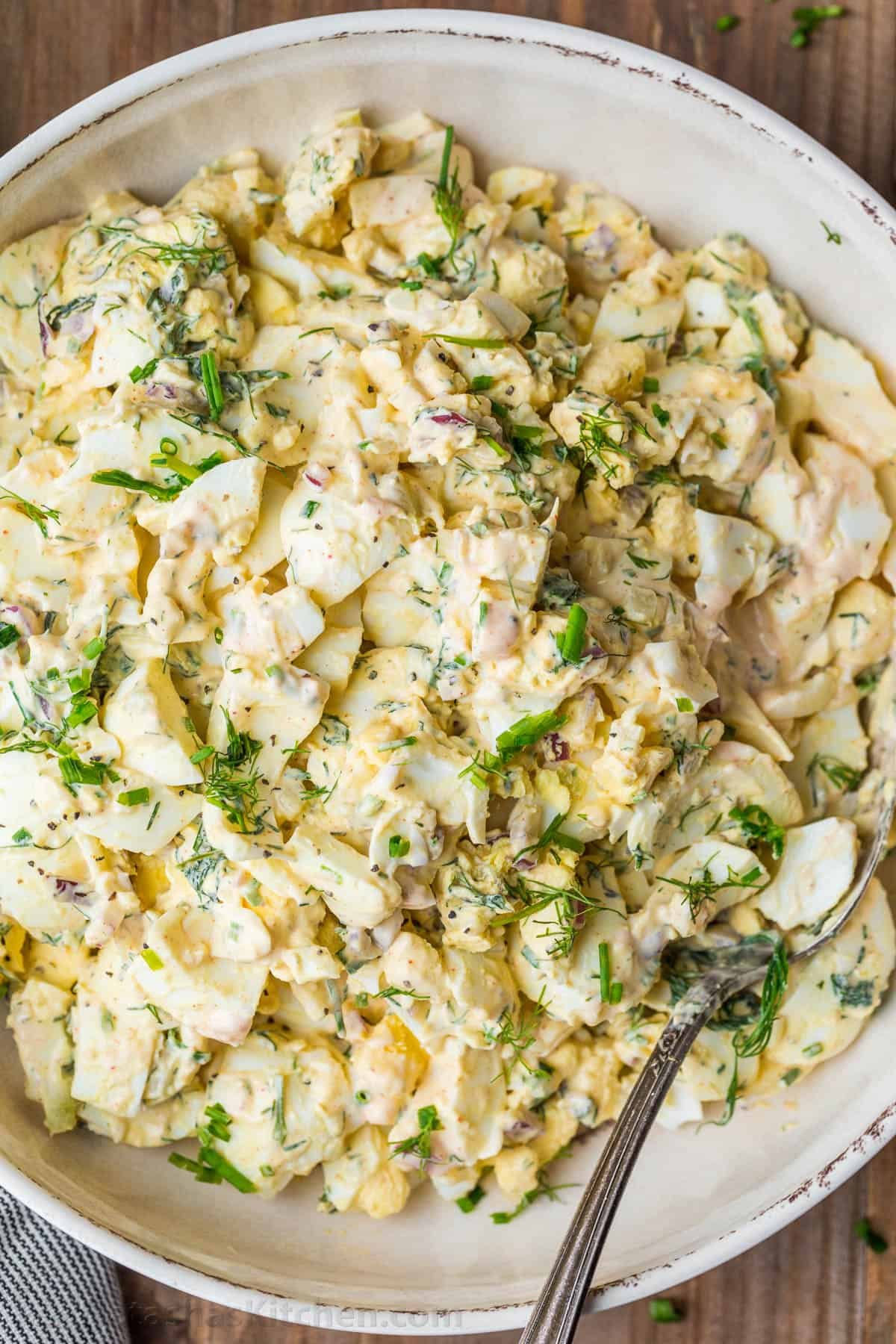 Truly the Best Egg Salad Recipe. Hard-boiled eggs with celery, dill, seasoning and chives in creamy dressing. Egg salad is a great way to use cooked eggs! #eggsalad #eggsaladrecipe #howtomakeeggsalad #eggs #eggrecipes #hardboiledeggs #natashaskitchen #Easter #Easterrecipes #Eastersalad Egg salad with creamy dressing garnished with dill and chives