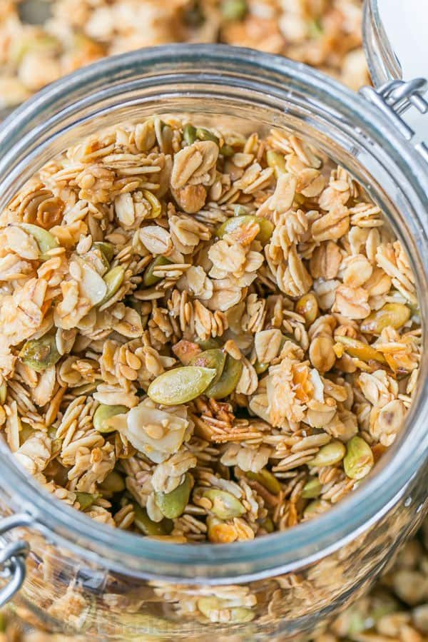 umpkin Flax Granola Recipe - crunchy, clustery and sweetened with honey | natashaskitchen.com How to store homemade granola in a jar with up-close shot of granola recipe to show seeds, oats, coconut