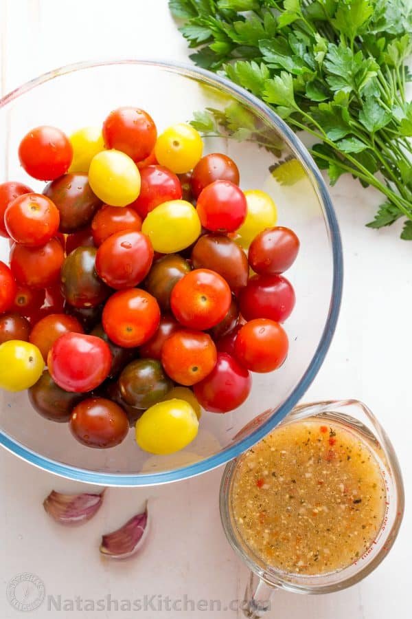 Ingredients for cherry tomatoes recipe with fresh cherry tomatoes, parsley, Italian dressing and garlic