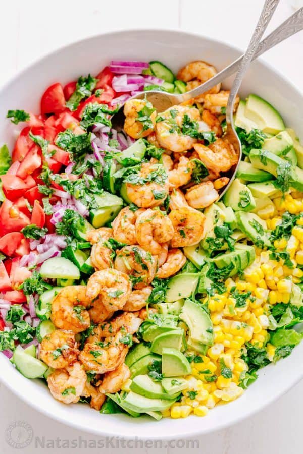 We could live off this shrimp avocado salad. It's crazy good and loaded with avocado, cucumbers, tomatoes, sweet corn and tossed with a light and easy cilantro-lemon dressing. This shrimp salad has all the best flavors of summer! WINNER!! | natashaskitchen.com