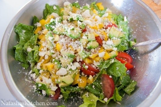 A large mixing bowl with avocado feta Caesar salad 