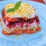 A piece of shuba with salmon on a white plate
