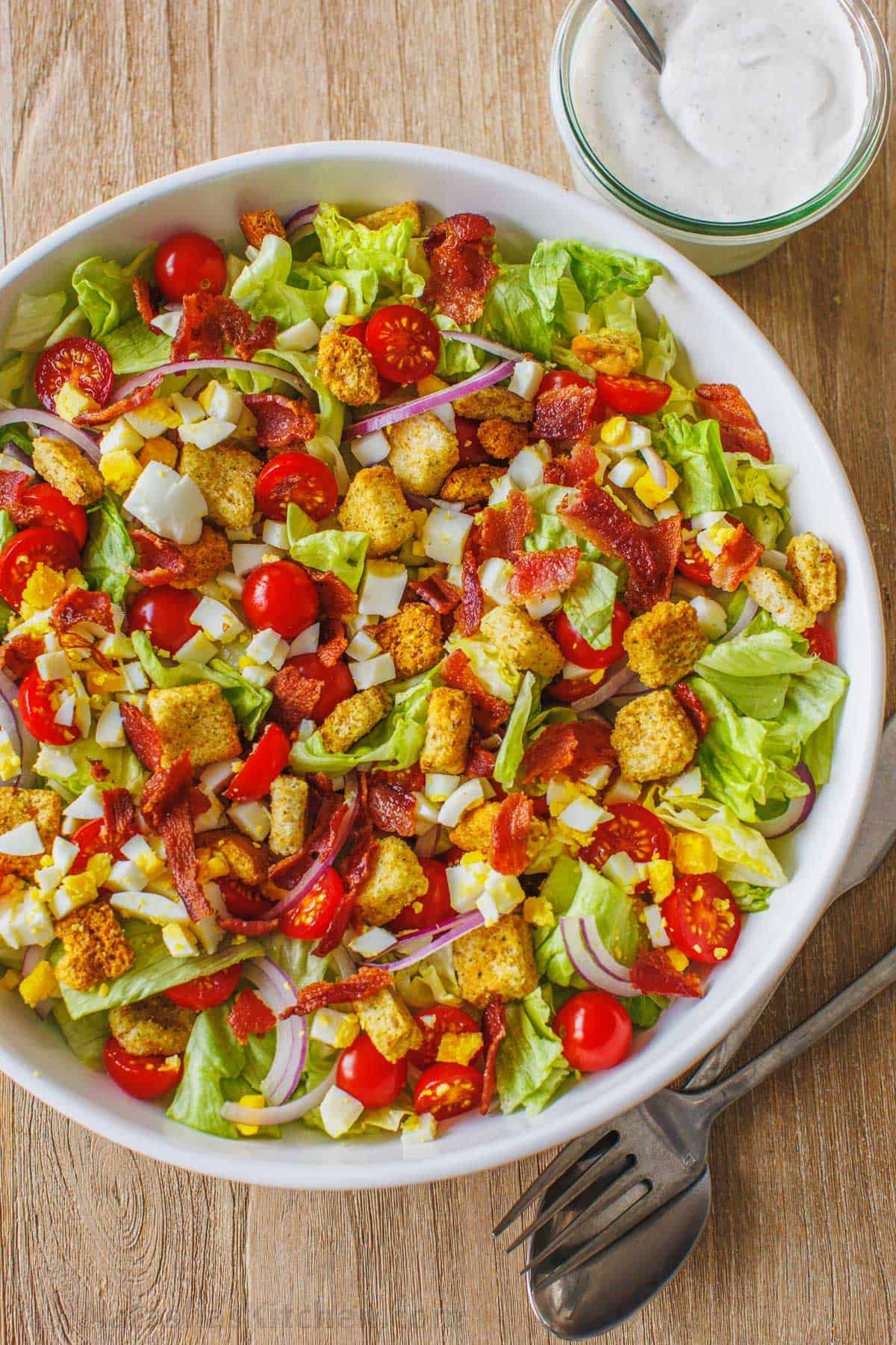 This restaurant-style Garden Salad is an easy salad recipe full of fresh ingredients and tossed with tangy homemade buttermilk dressing. A fresh garden salad in a large white bowl topped with croutons.