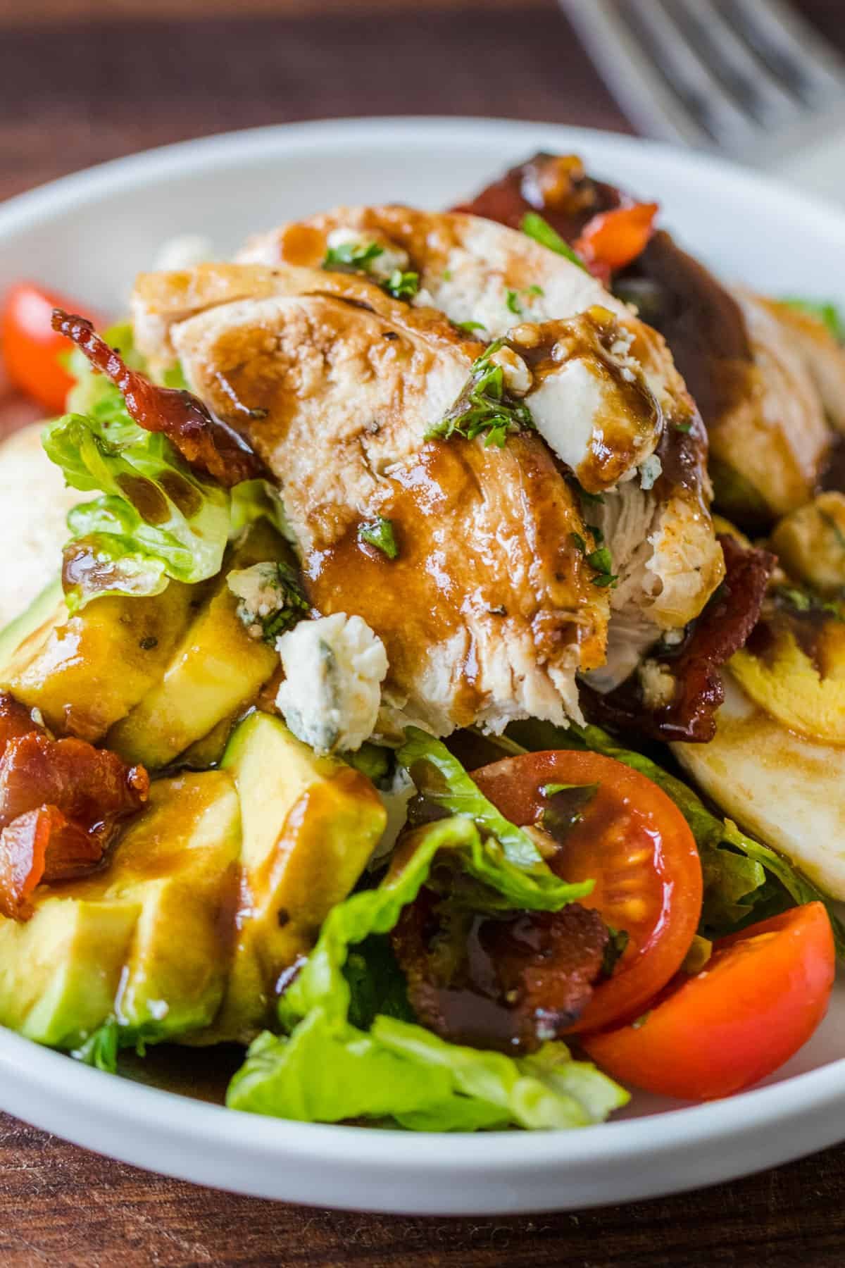 Easy Chicken Cobb Salad with the Best Cobb Salad Dressing! A protein-packed salad loaded with lettuce, tomatoes, chicken, avocado and cheese. Cobb salad served on a plate with chicken and cobb salad dressing drizzled over the top