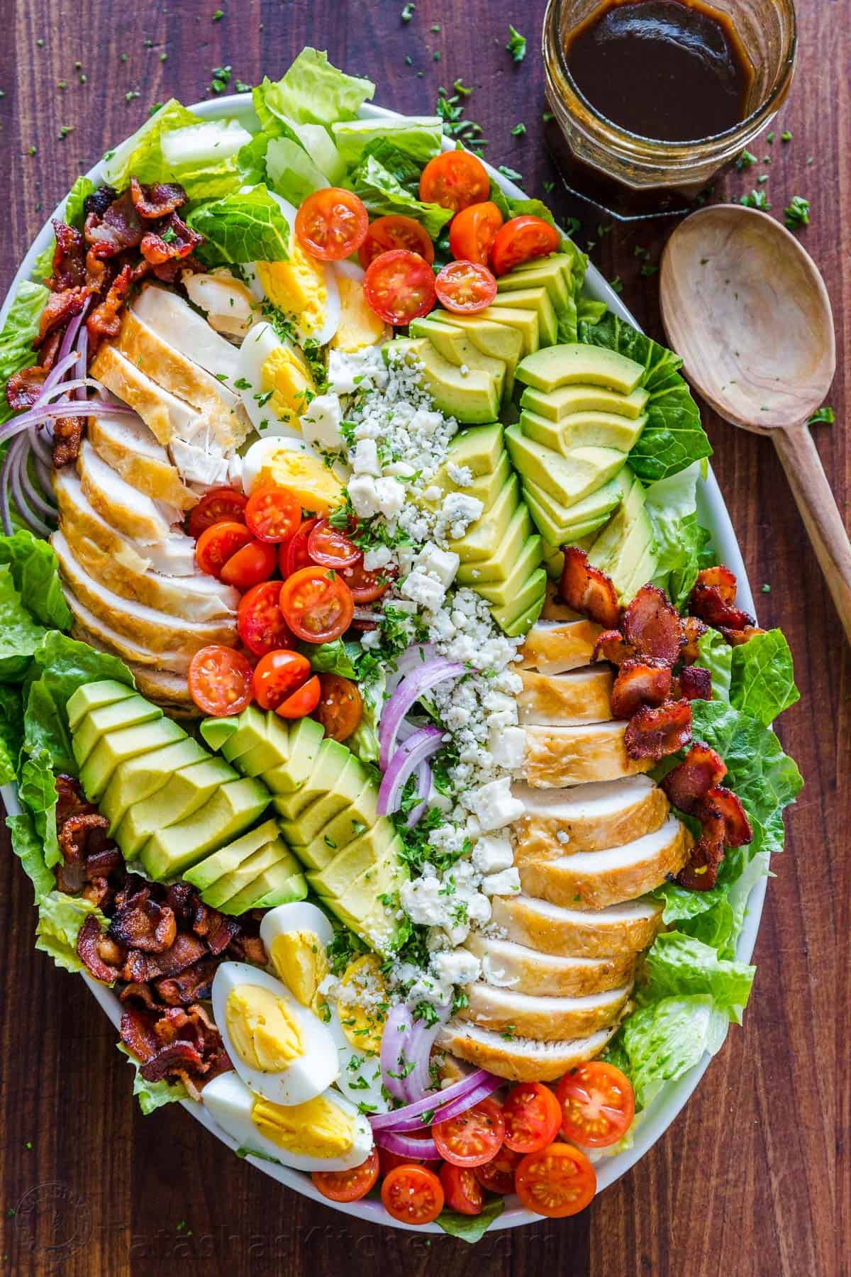 Easy Chicken Cobb Salad with the Best Cobb Salad Dressing! A protein-packed salad loaded with lettuce, tomatoes, chicken, avocado and cheese. Cobb Salad and dressing made ahead and arranged on a platter