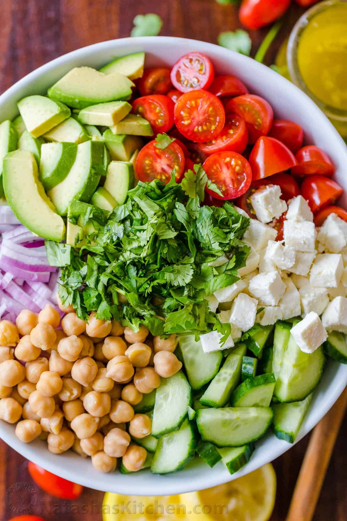 Chickpea Salad loaded with crisp cucumbers, juicy tomatoes, creamy avocado, feta cheese and chickpeas or garbanzo beans. Fresh, healthy and protein packed! #chickpeasalad #garbanzobeansalad #chickpeas #chickpeasaladrecipe #salad #saladrecipe #fetacheese #tomatosalad #avocadosalad #greeksalad #mediterraneansalad #natashaskitchen How to Make Chickpea Salad in a bowl