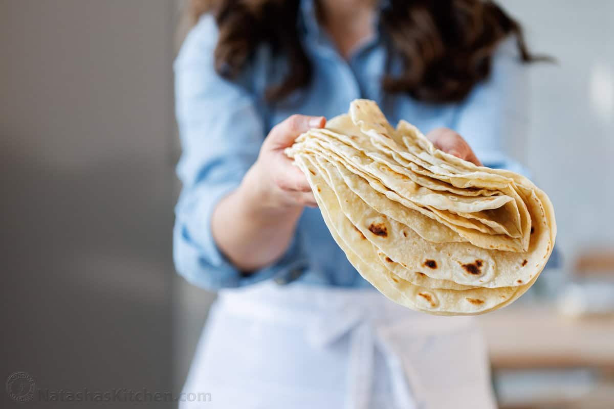 Natasha holding a stack of soft fresh tortillas