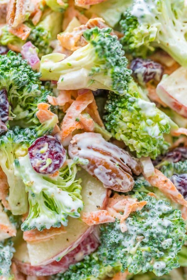 Broccoli Salad dressed with a creamy lemon dressing up close in serving bowl with broccoli, pecans, craisins, carrots, onion and apple