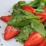 Spinach strawberry salad on a white plate