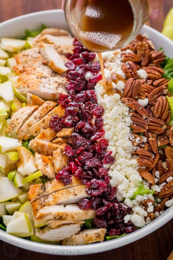 Serving Autumn Chopped Chicken Salad with balsamic Vinaigrette being drizzled over the top