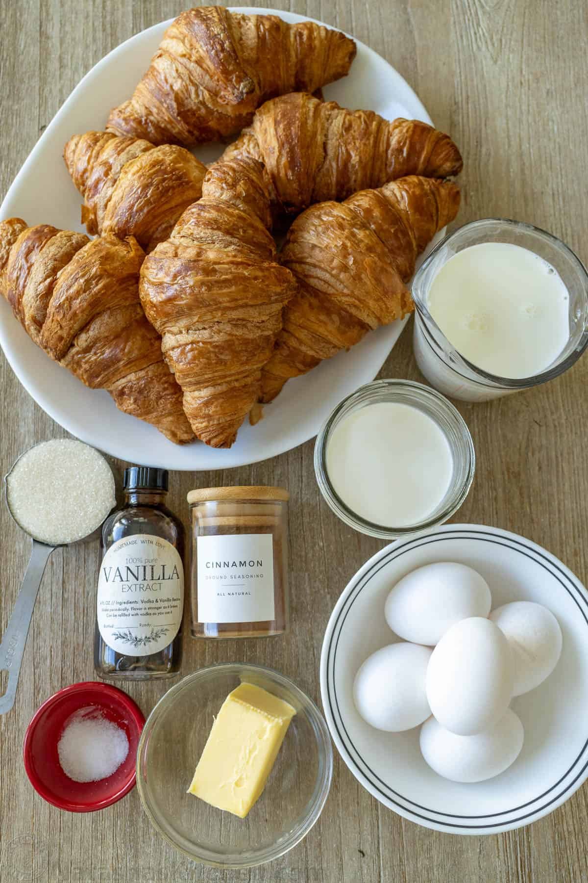 ingredients for breakfast casserole using croissants, sour cream, milk, sugar, vanilla, cinnamon, salt, butter and eggs
