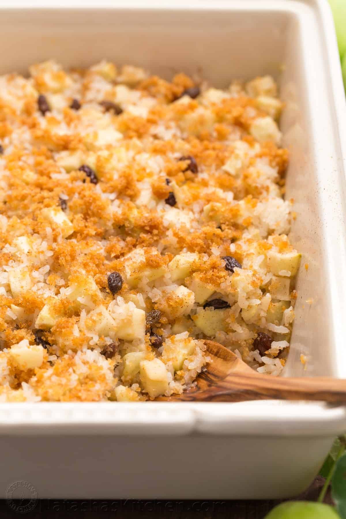 Apple rice pudding is Autumn comfort food. It is loaded with apples, cinnamon and a browned butter crunchy topping. A great way to use leftover white rice! | natashaskitchen.com Apple rice pudding with crunchy topping and serving spoon