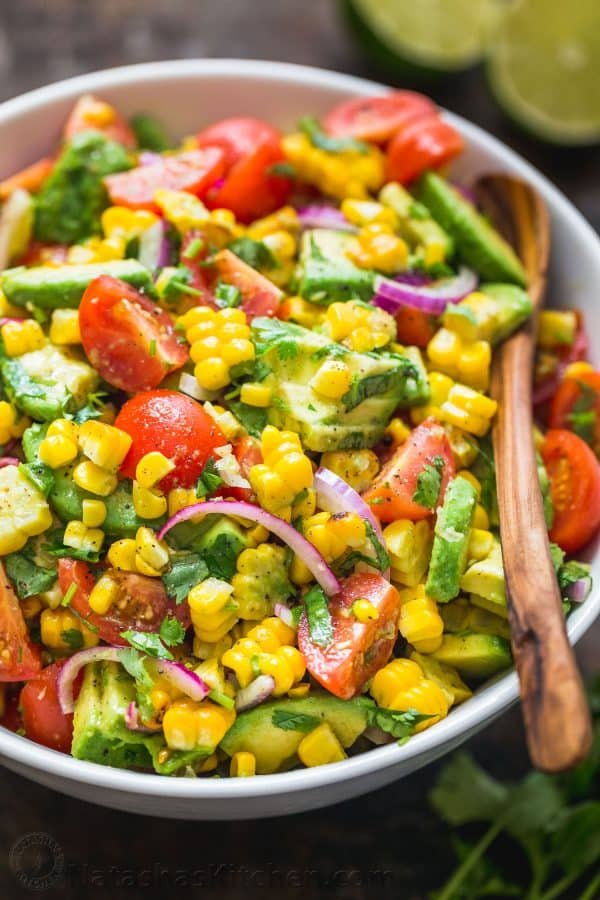 Fresh Corn salad with avocado mixed together in a bowl