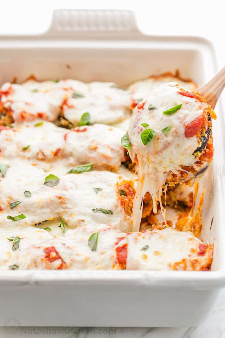 This Eggplant Parmesan recipe has crisp baked eggplant, flavorful marinara, and plenty of melted cheese to replicate a classic Italian dish. Baked Eggplant Parmesan slice with melted cheese